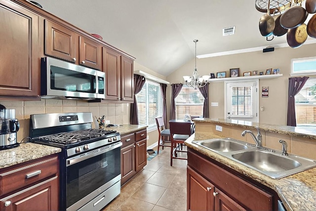 320 Atlanta Park Dr, Georgetown, TX 78628 - kitchen featuring appliances with stainless steel finishes, a sink, a chandelier, decorative backsplash, and vaulted ceiling