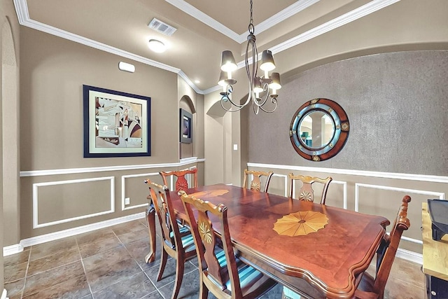 320 Atlanta Park Dr, Georgetown, TX 78628 - dining area with a chandelier, crown molding, a decorative wall, arched walkways, and wainscoting