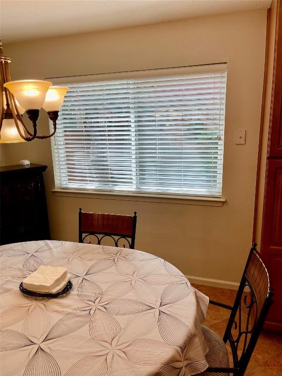4107 Columbine Dr, Austin, TX 78727 - tiled bedroom with a chandelier, multiple windows, and baseboards
