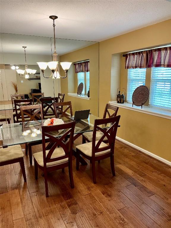 4107 Columbine Dr, Austin, TX 78727 - dining area with hardwood / wood-style flooring, healthy amount of natural light, a chandelier, baseboards, and a textured ceiling