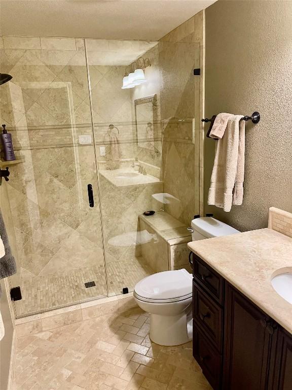 4107 Columbine Dr, Austin, TX 78727 - bathroom with vanity, a shower stall, toilet, and a textured wall