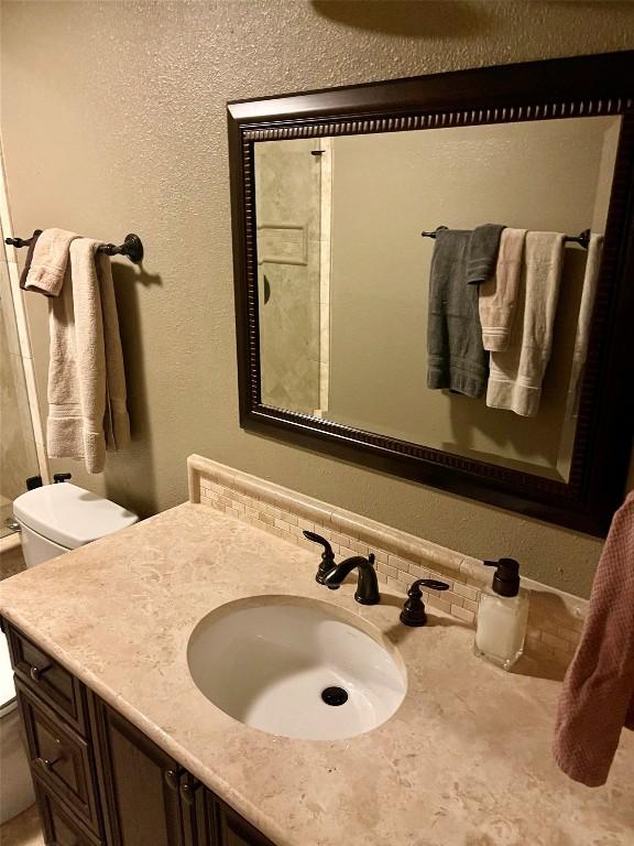 4107 Columbine Dr, Austin, TX 78727 - bathroom featuring a textured wall, vanity, and toilet