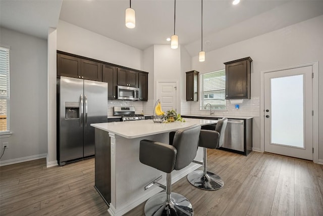 265 Fawn River Run, Kyle, TX 78640 - kitchen with appliances with stainless steel finishes, dark brown cabinets, backsplash, light countertops, and recessed lighting