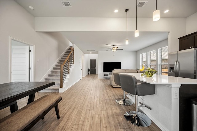 265 Fawn River Run, Kyle, TX 78640 - kitchen with light countertops, a ceiling fan, a breakfast bar, baseboards, and hanging light fixtures