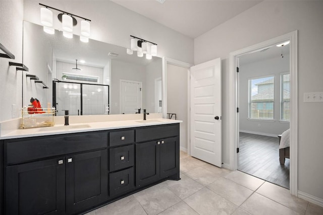 265 Fawn River Run, Kyle, TX 78640 - bathroom featuring a stall shower, double vanity, tile patterned flooring, and baseboards