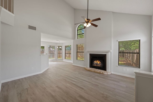 8407 Mount Shasta Cv, Round Rock, TX 78681 - unfurnished living room featuring high vaulted ceiling, ceiling fan, wood finished floors, a fireplace, and baseboards