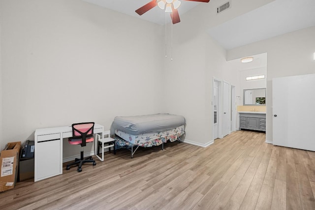 1908 San Antonio St Unit 313, Austin, TX 78705 - bedroom with a towering ceiling, light wood-type flooring, a ceiling fan, baseboards, and connected bathroom