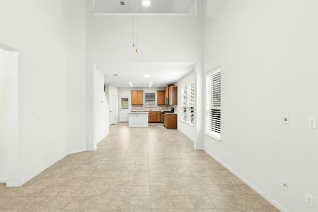 13208 Olivers Way, Manchaca, TX 78652 - unfurnished living room featuring baseboards and a towering ceiling