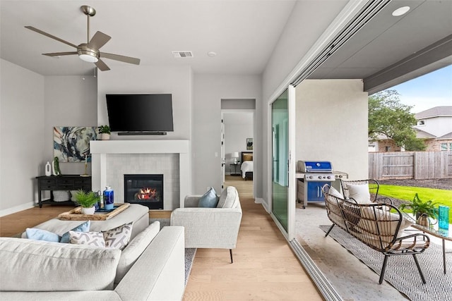 286 Canal Dr, Dripping Springs, TX 78620 - living area with light wood-type flooring, a fireplace, ceiling fan, and baseboards