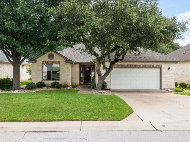 4914 Big Bend Trl, Georgetown, TX 78633 - single story home with a shingled roof, stone siding, a garage, and concrete driveway