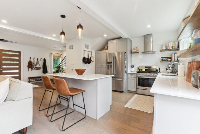 6505 Grover Ave Unit 1, Austin, TX 78757 - kitchen with wall chimney exhaust hood, stainless steel appliances, open shelves, a sink, and a breakfast bar area