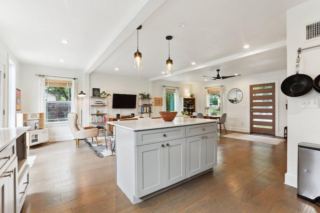 6505 Grover Ave Unit 1, Austin, TX 78757 - kitchen with light countertops, dark wood-type flooring, open floor plan, a kitchen island, and a ceiling fan