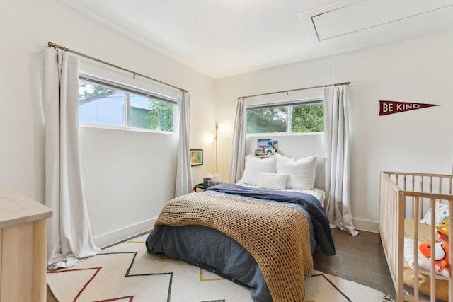 6505 Grover Ave Unit 1, Austin, TX 78757 - bedroom featuring multiple windows, attic access, light wood-type flooring, and baseboards