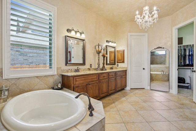 2513 Rusty Spur, Leander, TX 78641 - full bathroom featuring a bath, double vanity, a chandelier, tile patterned flooring, and a spacious closet