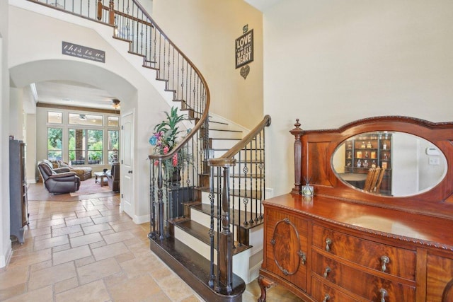 2513 Rusty Spur, Leander, TX 78641 - stairway featuring arched walkways, stone tile floors, baseboards, and a high ceiling