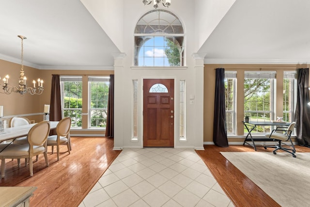 10617 Bramblecrest Dr, Austin, TX 78726 - entryway featuring a chandelier, plenty of natural light, a high ceiling, light wood-type flooring, and baseboards