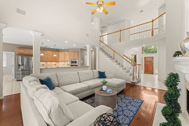 10617 Bramblecrest Dr, Austin, TX 78726 - living room featuring decorative columns, a high ceiling, a ceiling fan, and hardwood / wood-style floors