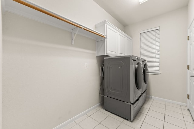 10617 Bramblecrest Dr, Austin, TX 78726 - laundry area featuring separate washer and dryer, cabinet space, baseboards, and light tile patterned floors