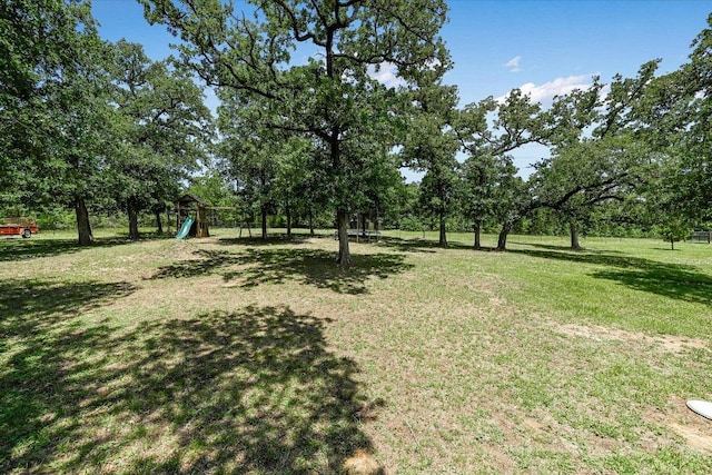 141 N Buckhorn Dr, Bastrop, TX 78602 - view of green lawn featuring a playground and view of scattered trees