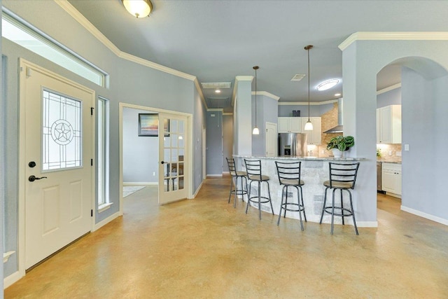 141 N Buckhorn Dr, Bastrop, TX 78602 - kitchen with stainless steel fridge, finished concrete floors, wall chimney exhaust hood, arched walkways, and crown molding