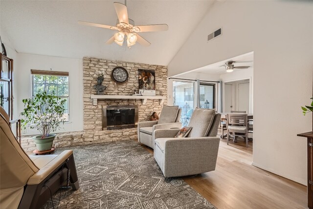 9206 Robins Nest Ln, Austin, TX 78729 - living area featuring ceiling fan, lofted ceiling, wood finished floors, and a stone fireplace