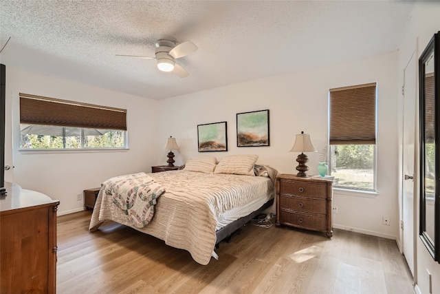 9206 Robins Nest Ln, Austin, TX 78729 - bedroom with light wood-style flooring, a ceiling fan, and a textured ceiling