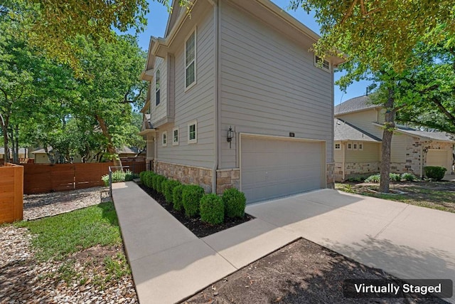11000 Anderson Mill Rd Unit 96, Austin, TX 78750 - view of home's exterior with a garage, stone siding, and driveway