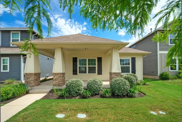 211 S Timber Brook Dr, Hutto, TX 78634 - view of front of home with covered porch, a front lawn, and roof with shingles