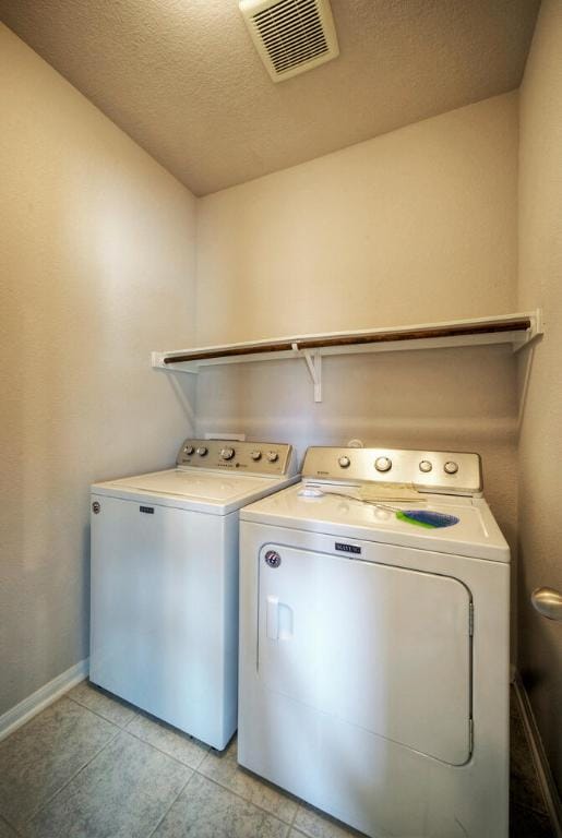 211 S Timber Brook Dr, Hutto, TX 78634 - washroom featuring washer and dryer, light tile patterned floors, and a textured ceiling