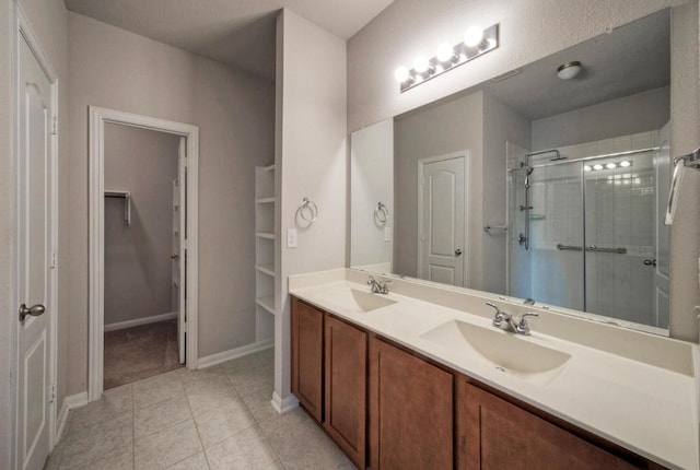 211 S Timber Brook Dr, Hutto, TX 78634 - full bathroom with a spacious closet, double vanity, a stall shower, and tile patterned floors