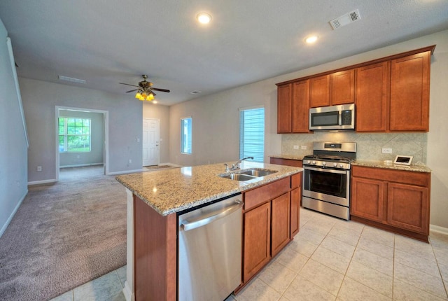211 S Timber Brook Dr, Hutto, TX 78634 - kitchen featuring stainless steel appliances, brown cabinets, light stone counters, decorative backsplash, and recessed lighting