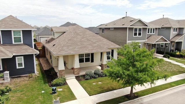 211 S Timber Brook Dr, Hutto, TX 78634 - view of front of home with a residential view, a porch, roof with shingles, a front yard, and stone siding