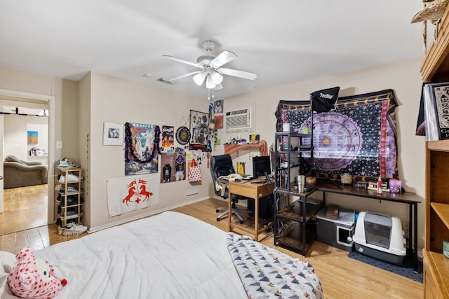 6805 Tulane Dr, Austin, TX 78723 - bedroom featuring a wall unit AC, wood finished floors, and a ceiling fan