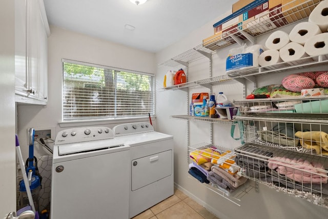 6805 Tulane Dr, Austin, TX 78723 - laundry room with washer and clothes dryer, cabinet space, light tile patterned floors, and baseboards