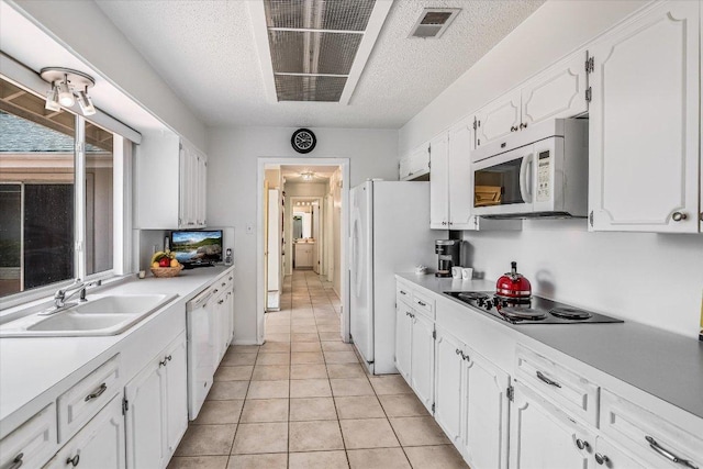 8600 Crest Ridge Cir, Austin, TX 78750 - kitchen featuring white appliances, white cabinets, light countertops, light tile patterned floors, and a textured ceiling