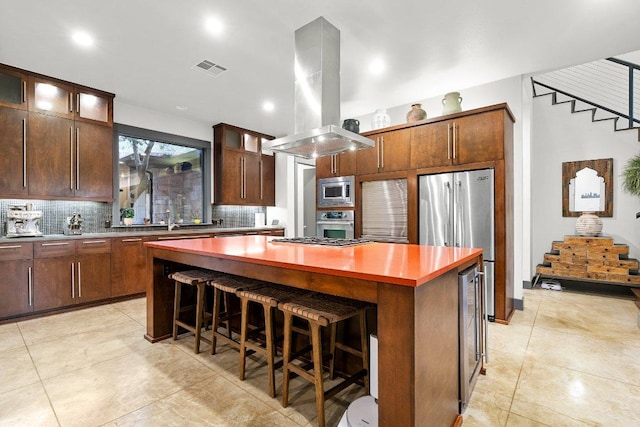 332 Rugged Earth Dr, Austin, TX 78737 - kitchen featuring stainless steel appliances, island exhaust hood, a kitchen island, tasteful backsplash, and recessed lighting