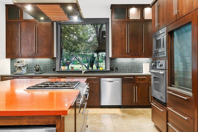 332 Rugged Earth Dr, Austin, TX 78737 - kitchen featuring stainless steel appliances, custom range hood, backsplash, and light tile patterned flooring