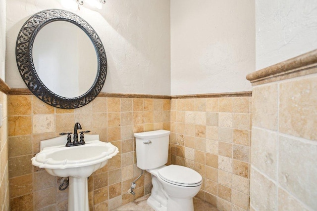 1252 Fall Creek Loop, Cedar Park, TX 78613 - bathroom with tile walls, toilet, wainscoting, and a textured wall