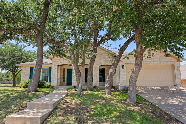1129 Wigwam Dr, Leander, TX 78641 - view of front of home featuring a garage, driveway, and stone siding