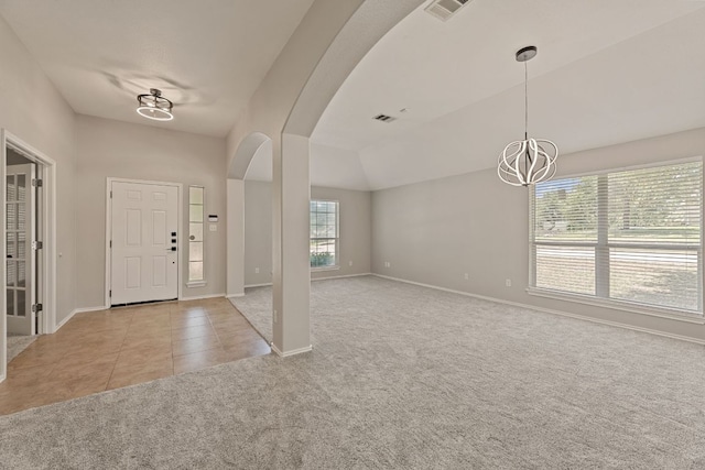 1129 Wigwam Dr, Leander, TX 78641 - carpeted foyer entrance with arched walkways, a chandelier, and tile patterned floors