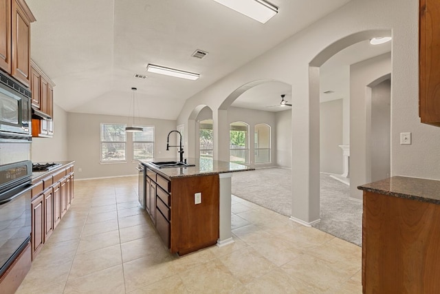 1129 Wigwam Dr, Leander, TX 78641 - kitchen featuring black appliances, brown cabinetry, dark stone counters, ceiling fan, and lofted ceiling