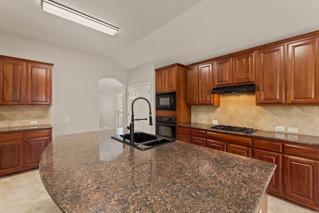 1129 Wigwam Dr, Leander, TX 78641 - kitchen featuring arched walkways, black appliances, vaulted ceiling, under cabinet range hood, and backsplash