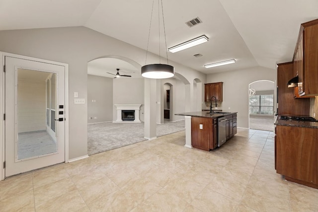 1129 Wigwam Dr, Leander, TX 78641 - kitchen with arched walkways, lofted ceiling, stainless steel appliances, ceiling fan, and a fireplace