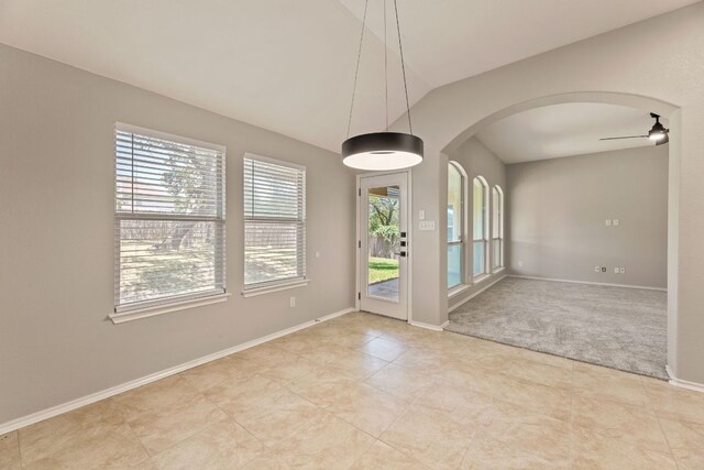 1129 Wigwam Dr, Leander, TX 78641 - empty room with arched walkways, healthy amount of natural light, light tile patterned flooring, ceiling fan, and vaulted ceiling