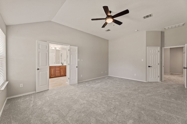 1129 Wigwam Dr, Leander, TX 78641 - unfurnished bedroom featuring vaulted ceiling, light colored carpet, multiple windows, ensuite bath, and ceiling fan