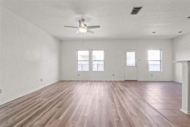 232 Wells Bnd, Hutto, TX 78634 - unfurnished living room featuring a ceiling fan, light wood finished floors, baseboards, and a fireplace