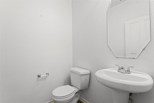 232 Wells Bnd, Hutto, TX 78634 - half bath with toilet, baseboards, and a sink