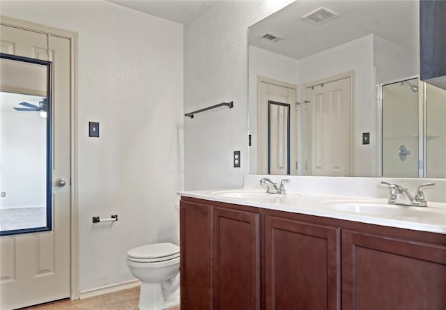 232 Wells Bnd, Hutto, TX 78634 - bathroom with double vanity, toilet, a shower stall, tile patterned flooring, and a ceiling fan