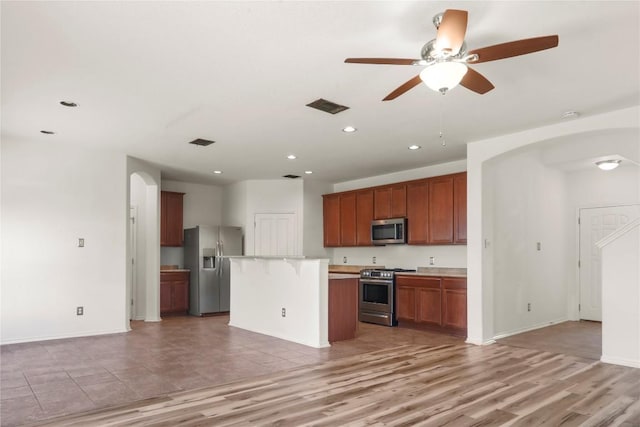 232 Wells Bnd, Hutto, TX 78634 - kitchen featuring appliances with stainless steel finishes, arched walkways, open floor plan, recessed lighting, and ceiling fan