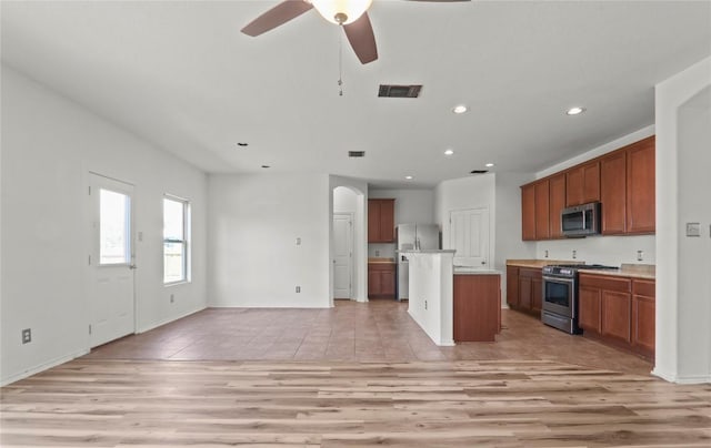 232 Wells Bnd, Hutto, TX 78634 - kitchen featuring stainless steel appliances, recessed lighting, ceiling fan, brown cabinetry, and light countertops